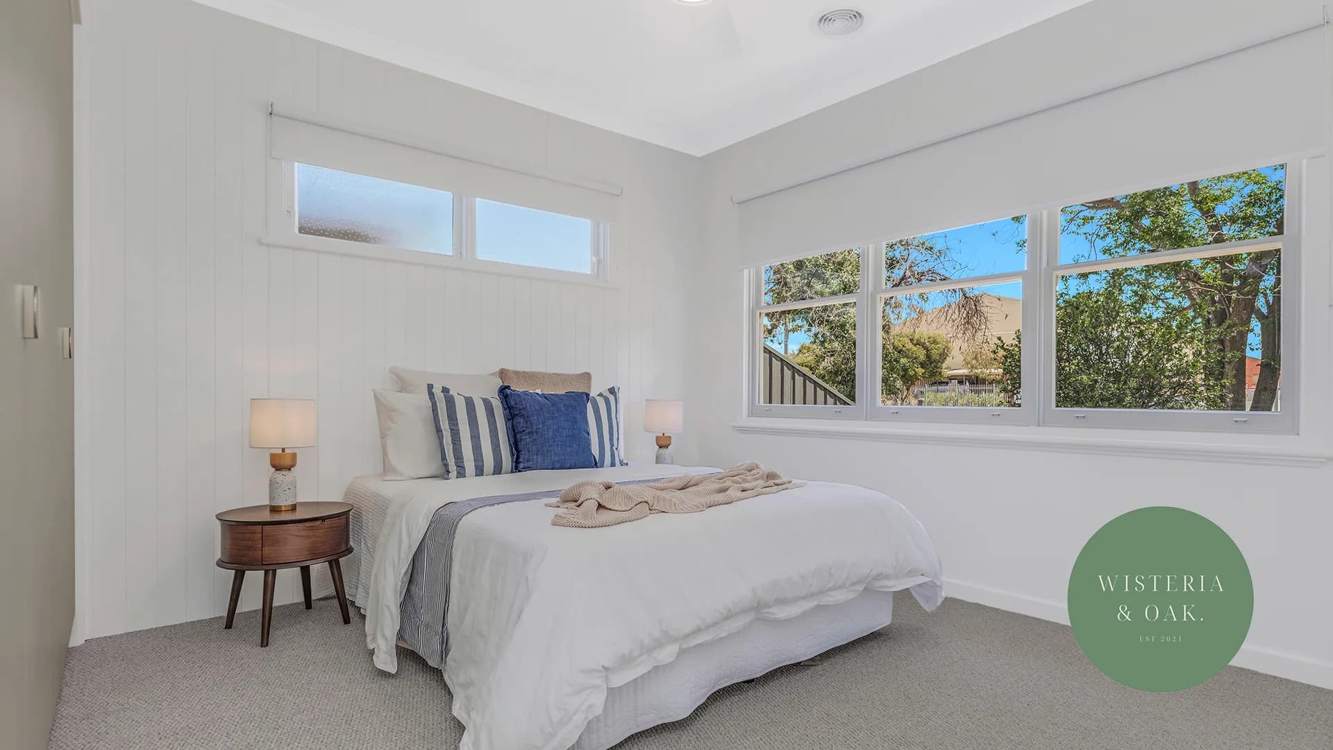 Bedroom with white bedding, a navy cushion and a timber bedside table at Bowen Street, Echuca