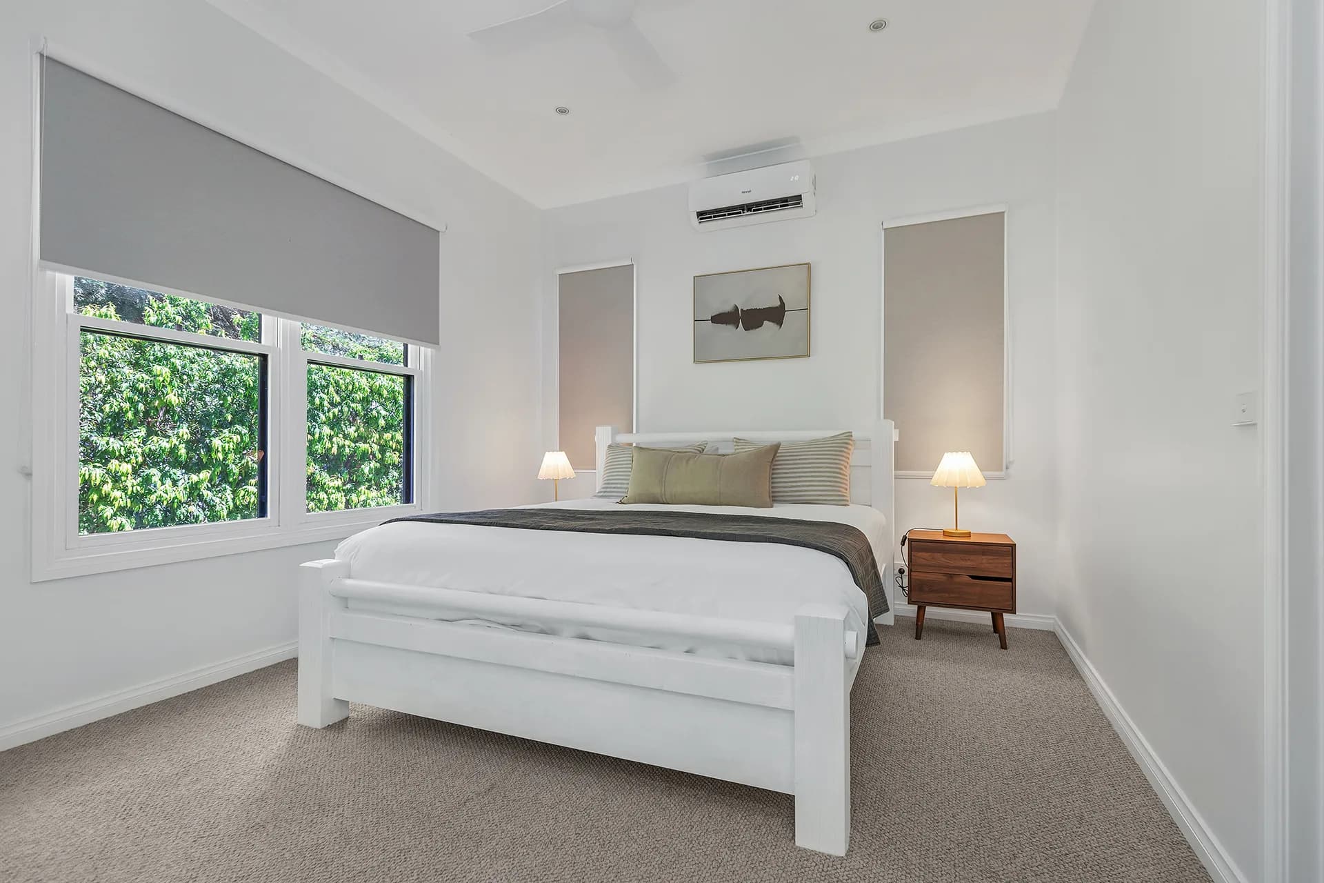 Bedroom with a white bed frame, green cushions and a window to the garden at Dickson Street, Echuca