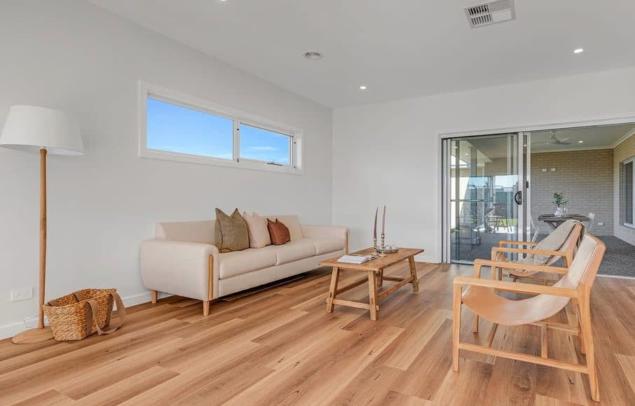 Second living space styled for sale by Wisteria & Oak, with a pale sofa, floor lamp, timber armchairs and doors to the alfresco