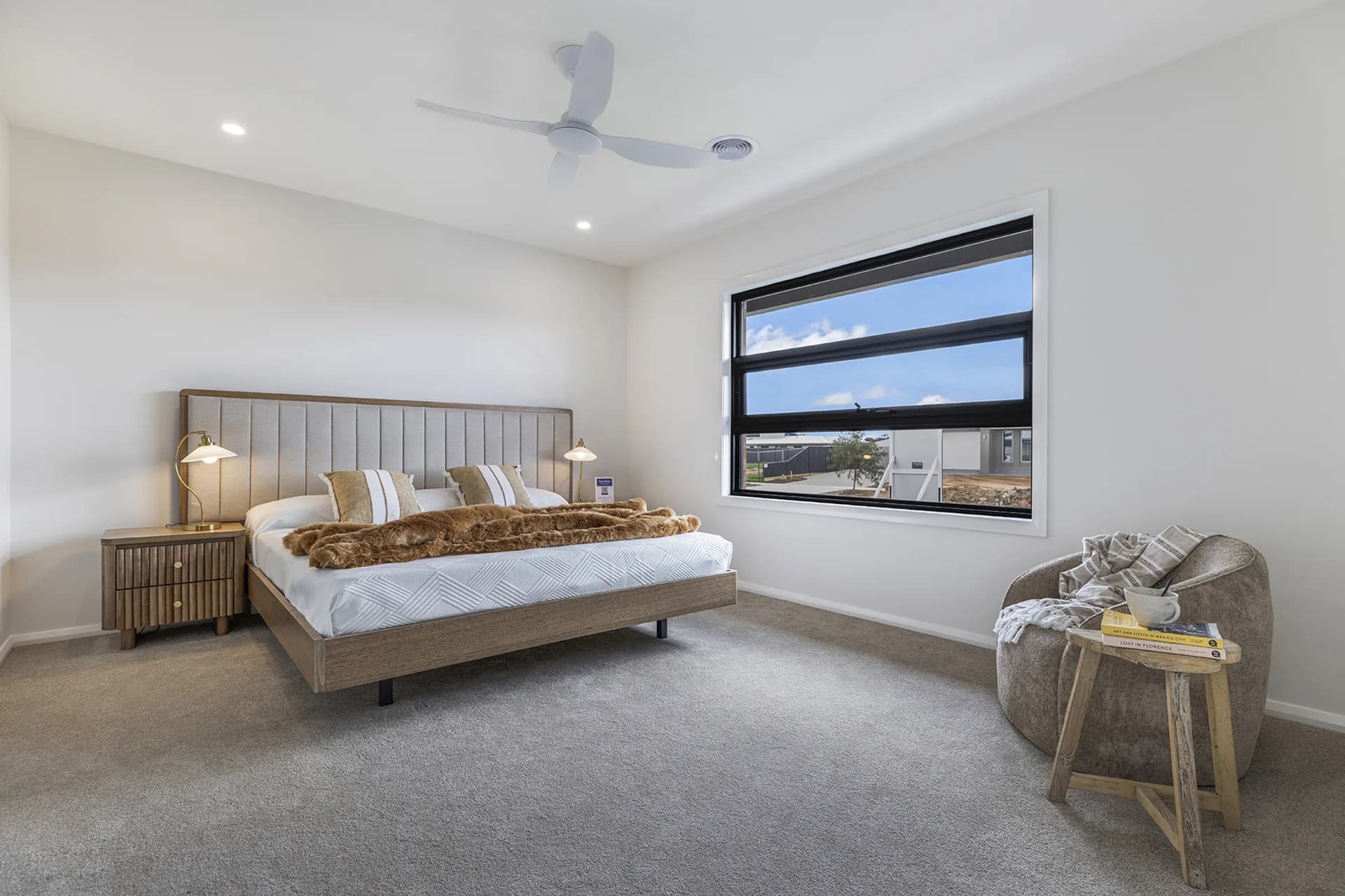 Main bedroom with a fluted bedhead, timber bedsides and a window to the paddock at Finch Street, Moama