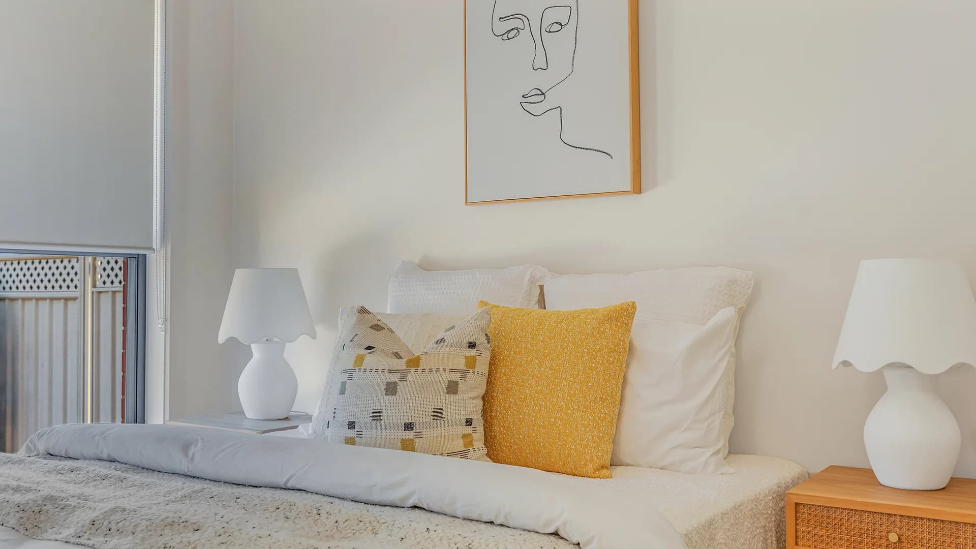Bedroom with white bedding, mustard cushions and matching bedside lamps at Haverfield Street, Echuca