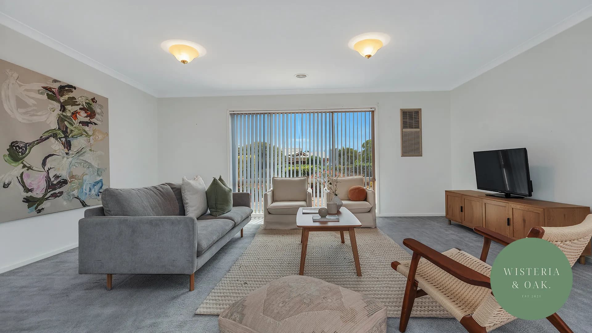 Living room with a grey sofa, timber sideboard and sliding doors to the garden at Luth Street, Echuca