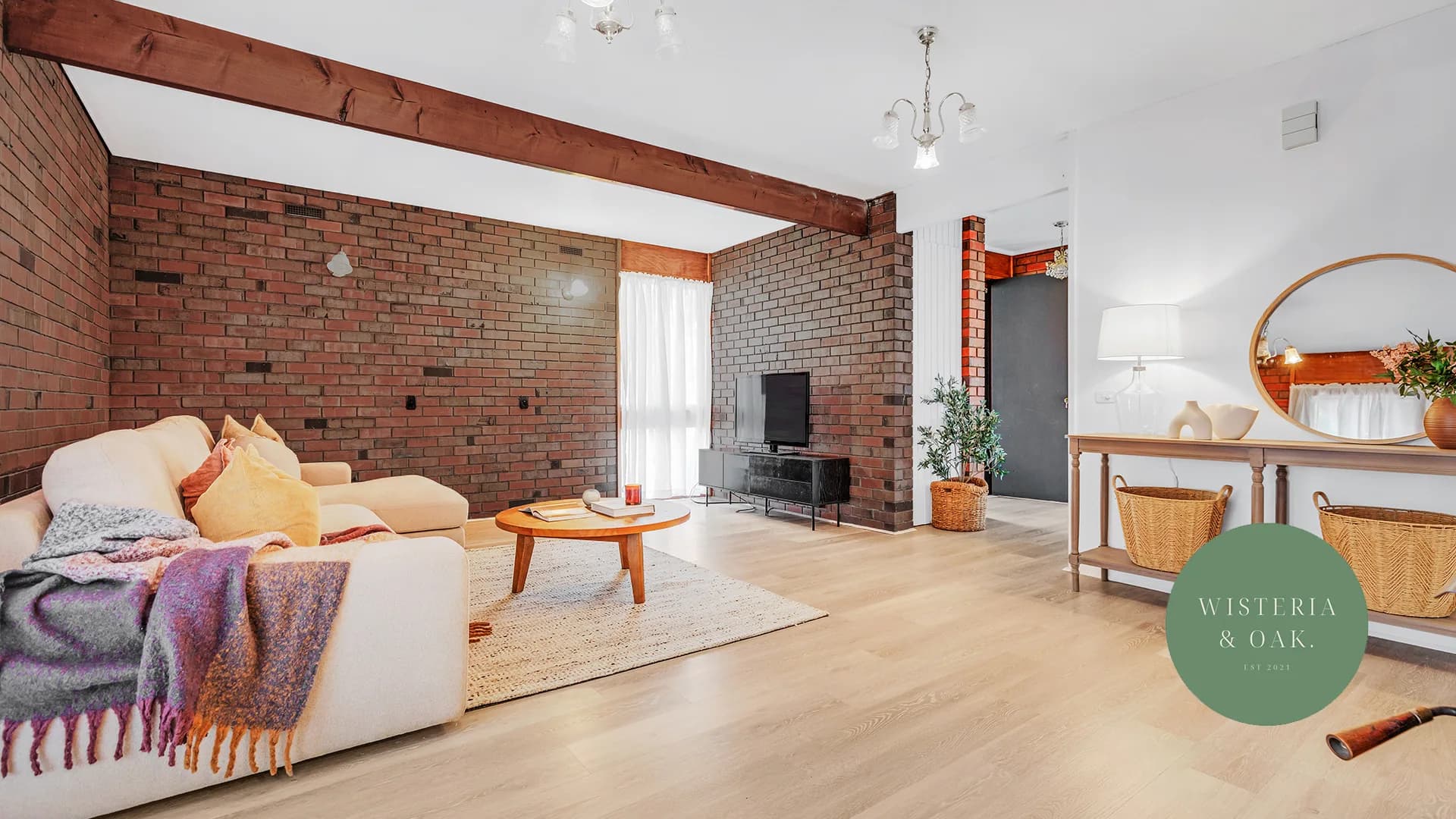 Living room with exposed brick, timber ceiling beams and a pale sofa at McKenzie Street, Echuca